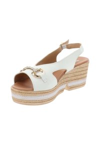 Sandalo con tacco a cuneo in pelle bianca, con punta aperta, design slingback, catena dorata decorativa e piattaforma in juta intrecciata. Presenta un plantare beige.