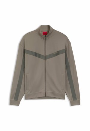 Beige zip-up track jacket with dark gray diagonal and sleeve stripes, two front pockets, and a small "HUGO" logo on the chest.