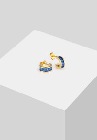 Orecchini a cerchio dorati con pietre rettangolari blu incastonate in un design curvo, con una finitura lucida e supporto posteriore visibile.