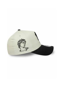 Casquette de baseball avec une partie avant crème et une visière noire, ornée d'un design en fil noir brodé représentant une sculpture classique sur le côté.