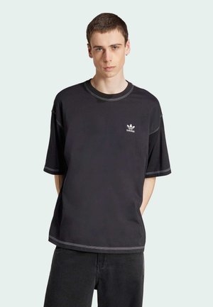 Schwarzes Baumwoll-T-Shirt mit kurzen Ärmeln, kontrastierenden weißen Nähten und einem kleinen weißen Logo auf der linken Brust. Lässige Passform.