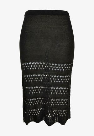 Must mustarist lapiga, millel on laineline äär ja horisontaalsed triibud avatud kudumisest ja ühtlasest kangast, mis lisavad tekstuuri ja kujunduse mitmekesisust.