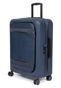 Valigia rigida navy con frontale testurizzato, tasca con zip, manico estraibile e quattro ruote girevoli per una facile mobilità.