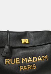 Borsa in pelle nera con una texture liscia. Presenta la scritta dorata "RUE MADAM PARIS" e un dettaglio rettangolare dorato sulla patta.