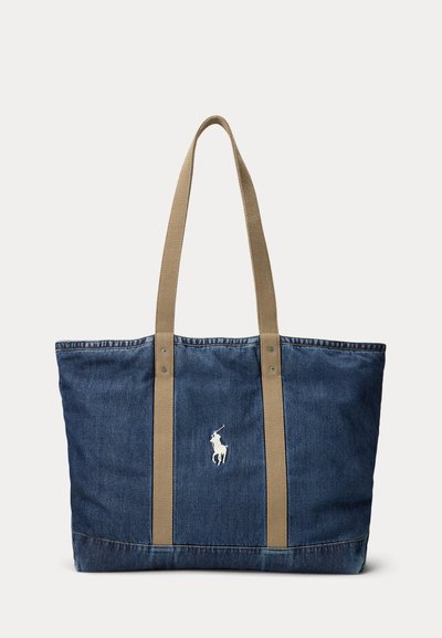 Τσάντα ώμου από μπλε τζιν με μπεζ λουριά και λευκό κεντημένο λογότυπο παίκτη πόλο στο κέντρο μπροστά.