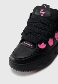 Czarne sneakersy z chropowatej skóry, różowymi akcentami, grubymi sznurówkami i wytłaczanym logo. Okrągły czubek i gumowa podeszwa z dobrze trzymającym gripem.