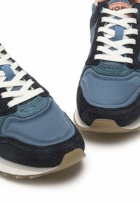 Sneaker navy e azzurro chiaro in suede e tessuto, con lacci bianchi, punta rotonda, suola in gomma e design texturizzato.