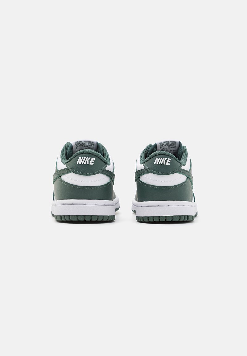 Zapatillas Nike verdes y blancas con parte superior de cuero suave, cuello acolchado y suela de goma texturizada con patrones de agarre elevados.