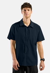 Marineblauw kortslipshirt van textuurstof, met een knoopsluiting aan de voorkant, een kraag en een borstzak. Slank model.