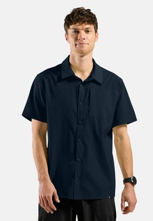 Marineblauw kortslipshirt van textuurstof, met een knoopsluiting aan de voorkant, een kraag en een borstzak. Slank model.