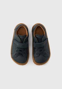 Σκούρα μπλε δερμάτινα παπούτσια με υφή, που διαθέτουν λουράκι με βέλκρο και ελαστικές κορδόνια, συμπληρωμένα με καφέ λαστιχένια σόλα.