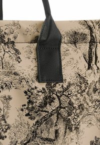 Borsa tote in tessuto beige con un motivo di alberi neri, con una resistente maniglia in tessuto nero e superficie testurizzata.