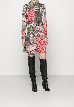 Wielokolorowa sukienka koszulowa z wzorem, długimi rękawami i kołnierzykiem, z paskiem w talii. Połączona z czarnymi skórzanymi kozakami do kolan.