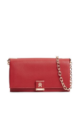 Pochette en cuir rouge texturé avec bandoulière chaîne dorée et fermoir logo doré sur le rabat avant, présentée sur fond blanc.