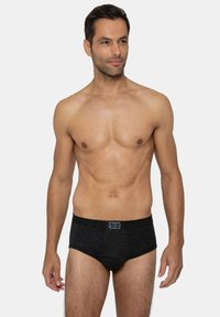 Slip in cotone nero con texture a coste, fascia elastica con etichetta del logo, design attillato e taglio classico.