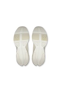 Sottopiedi per scarpe, di colore beige chiaro, in materiale gommoso testurizzato, con scanalature distinte e logo del marchio sul tallone.