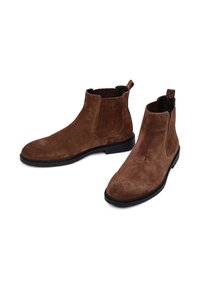 Stivaletti in suede marrone con pannelli laterali elasticizzati e linguette per il pull-on. Presentano una texture liscia e una suola in gomma nera per una buona aderenza.