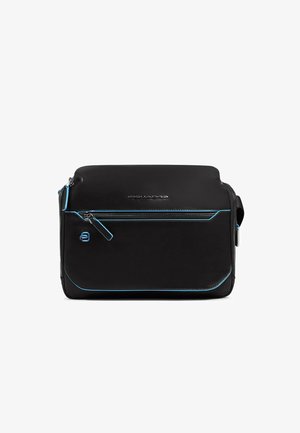 Bolso de cuero negro con costuras de acento en azul brillante. Cuenta con un bolsillo frontal con cremallera y una textura suave. Forma rectangular compacta.
