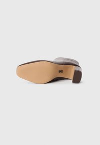 Brown leather heeled boot with a rounded toe, textured shaft, and a smooth sole. The heel is block-shaped, enhancing stability.
