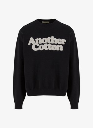 Fekete pamut pulóver, amelyen egy struktúrált, kiemelkedő fehér "Another Cotton" logó található az elején. Bordás mandzsetta és szegély.