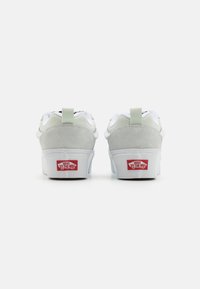 Sneaker in suede bianco e grigio con colletto imbottito, dotate di una linguetta sul tallone verde e del logo rosso "Off the Wall" sulla suola.