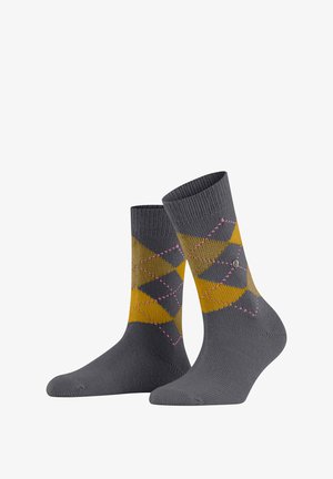 Graue Socken mit einem Rautenmuster in Gelb und Dunkelgrün, verziert mit pinken Akzenten. Hergestellt aus gestricktem Stoff mit einem gerippten Bund.