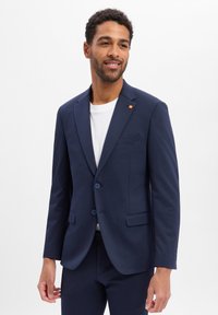 Marineblazer aus glattem Stoff, mit zwei Knöpfen, einer einzelnen Brusttasche und einem dezenten orangefarbenen Akzent am Revers.