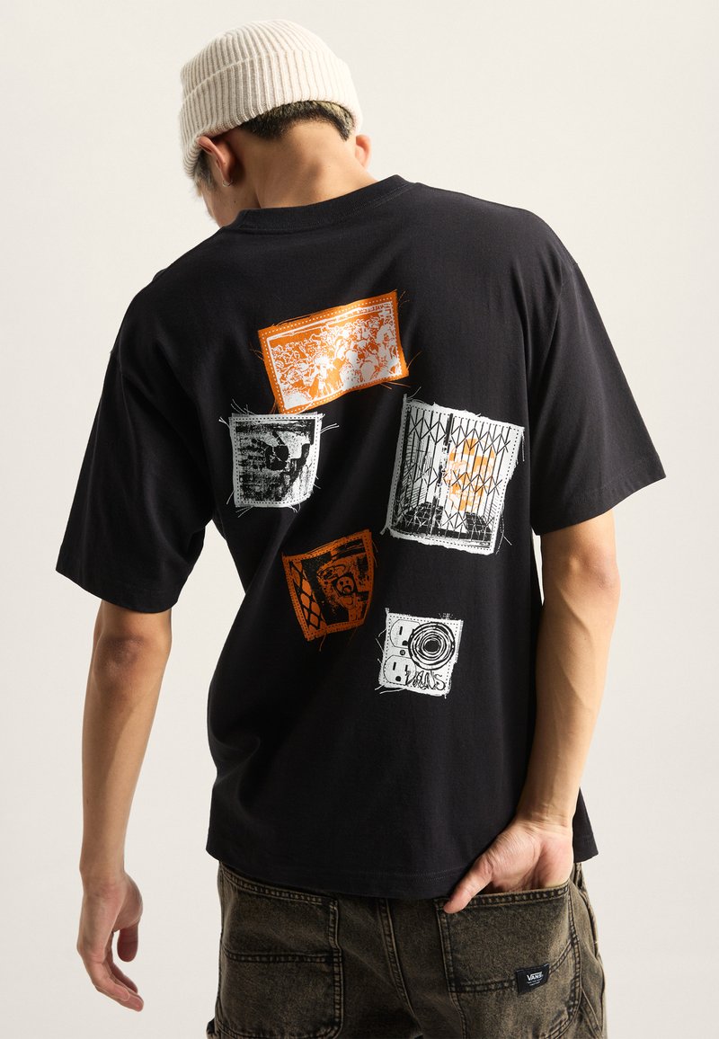 Sort bomulds t-shirt med flerfarvede grafiske tryk på ryggen, med orange, hvidt og gråt design i forskellige former og mønstre.