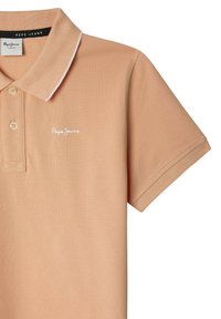 Polo beige con tessuto a trama, caratterizzato da un colletto bianco, due bottoni e un logo ricamato bianco sul petto.