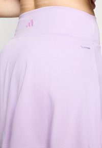 Világoslila sport szoknya, texturált hálós dizájnnal. Rugalmas derékpánttal rendelkezik, és az oldalán "CLIMACOOL" márkajelzéssel ellátott.