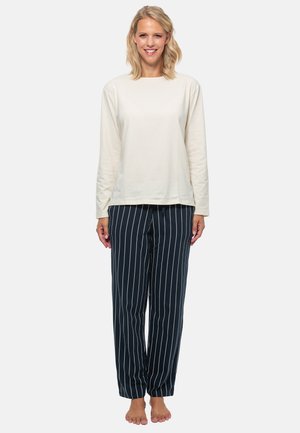 Långärmad krämfärgad topp som matchas med marinblå randiga pyjamasbyxor. Byxorna har vertikala vita ränder och en avslappnad passform.