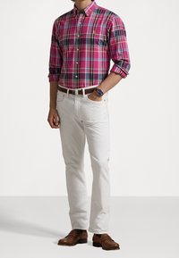 Rutig rosa och blå skjorta, vita byxor, bruna dress shoes, med klocka och bälte, samt upprullade ärmar.