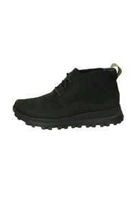Botas negras de tobillo de ante, con suela de goma gruesa y antideslizante, punta redonda y diseño de cordones; incluye una pestaña verde en el talón.