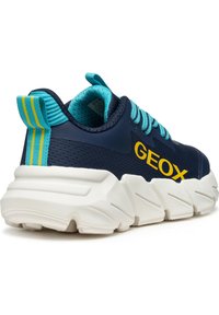 Sneaker navy con tomaia in tessuto traspirante, dettagli turchesi, logo "GEOX" giallo e una suola bianca spessa con dettagli testurizzati.