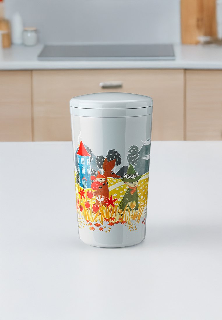 Ceramiczny pojemnik o błyszczącej białej powierzchni, z kolorową ilustracją przedstawiającą zwierzęta, kwiaty i dom. O zaokrąglonym kształcie, z dopasowaną pokrywką.