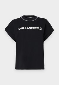 Melna kokvilnas t-kreklu ar īsām piedurknēm, ar baltu "KARL LAGERFELD" logo uz krūšu un apaļu kakla izgriezumu ar kontrastējošu apdari.