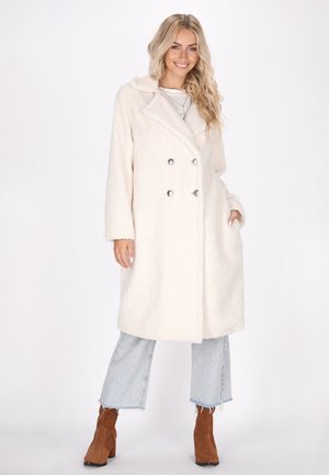 Double-breasted cream coat made of textured fleece, featuring a wide collar, two front pockets, and silver buttons for closure.