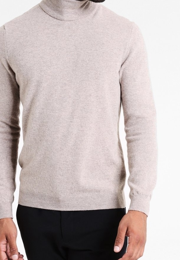 Ljus beige turtleneck-tröja i ett mjukt, texturerat material. Skräddarsydd design med ribbade ärmslut och nederkant, vilket skapar en strömlinjeformad silhuett.