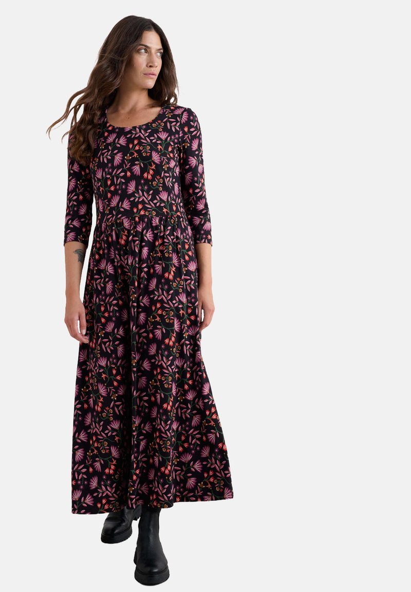 Duga crna haljina s tričetvrtastim rukavima, s cvjetnim uzorkom u ružičastoj i narančastoj boji. Izrađena od elastične tkanine, ima raširenu siluetu.