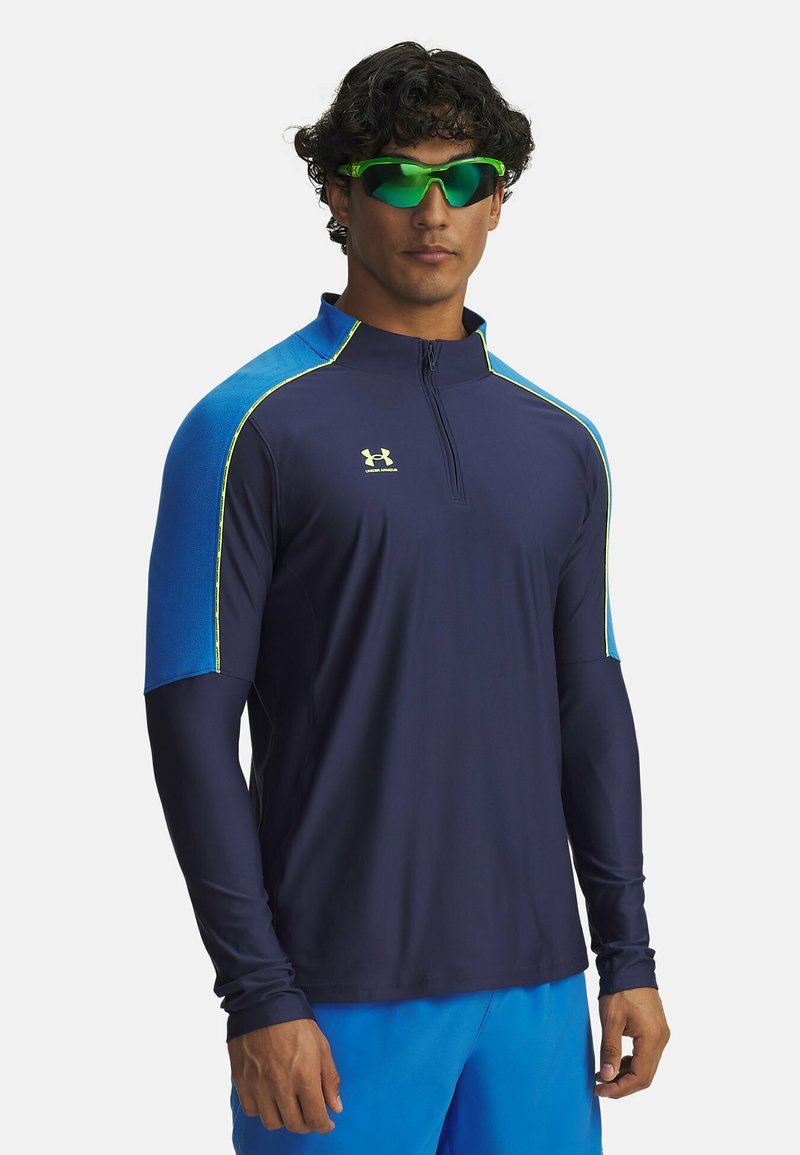 Navy athletic long-sleeve top with a high collar, featuring blue shoulder accents and neon yellow seams. Moisture-wicking, fitted design.