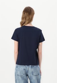 T-shirt in cotone blu navy con maniche corte, scollo a giro e vestibilità rilassata. Design semplice, senza motivi o dettagli visibili.