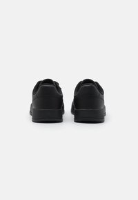 Sneaker neri con esterno in pelle liscia, punta rotonda, design a profilo basso e dettagli testurizzati sul tallone.