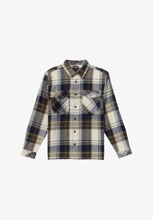 Rutig skjorta gjord av tjockt tyg; har färgerna marinblå, beige och krämvit. Två bröstfickor med klaffar, långa ärmar och knäppning framtill.