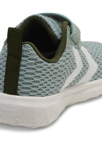 Sneaker a rete azzurro chiaro con finitura testurizzata. Presenta un design a strisce bianche, un tab verde sul tallone e una suola bianca.