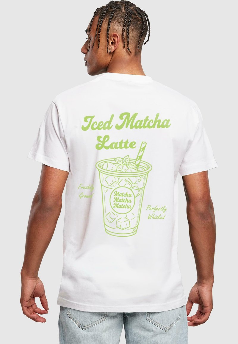 Bílý tričko s zelenou grafikou šálku označeného "Iced Matcha Latte" s kostkami ledu a mátovými lístky.