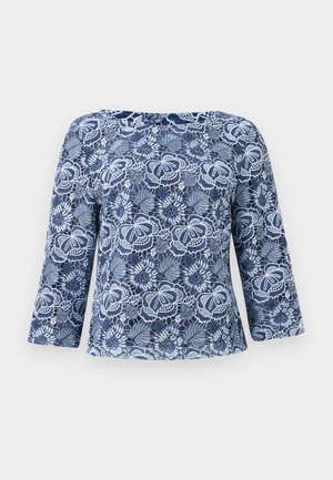 Haut à manches longues en dentelle bleue avec motifs floraux, doté de bords festonnés et d'un col bateau.