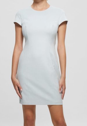 Robe ajustée bleu clair avec des manches courtes, encolure ronde, texture lisse et silhouette élégante, se prolongeant au-dessus du genou.