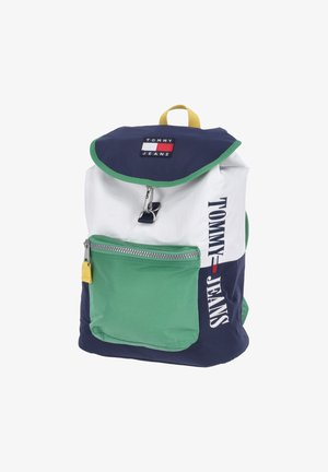 Sac à dos avec rabat bleu, corps supérieur blanc, poche avant verte et marquage "Tommy Jeans" sur le rabat et sur le côté en bleu, blanc, rouge et vert.