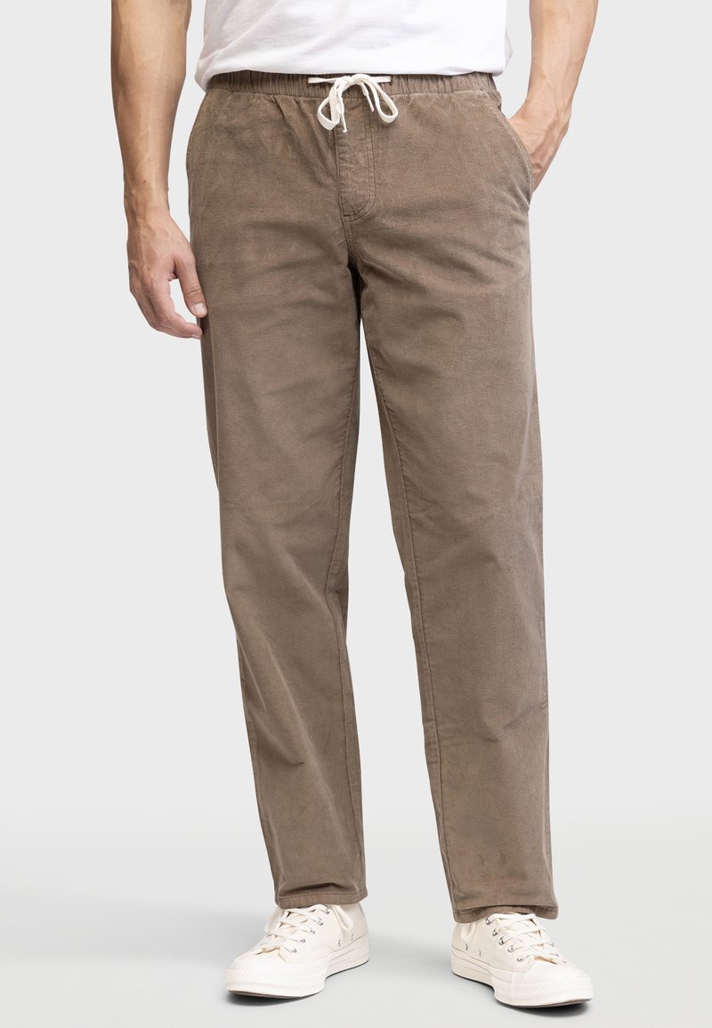 Brown, lightweight, drawstring pants with a relaxed fit and side pockets. Textured fabric adds a subtle depth to the overall design.