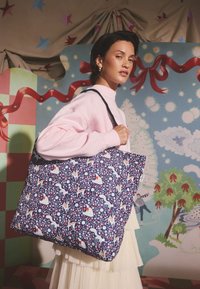 Nagy méretű, tengerészkék színű vászontáska virág- és állatmintával. Fekete vállpántokkal ellátva. Simogató tapintású, puha anyag.